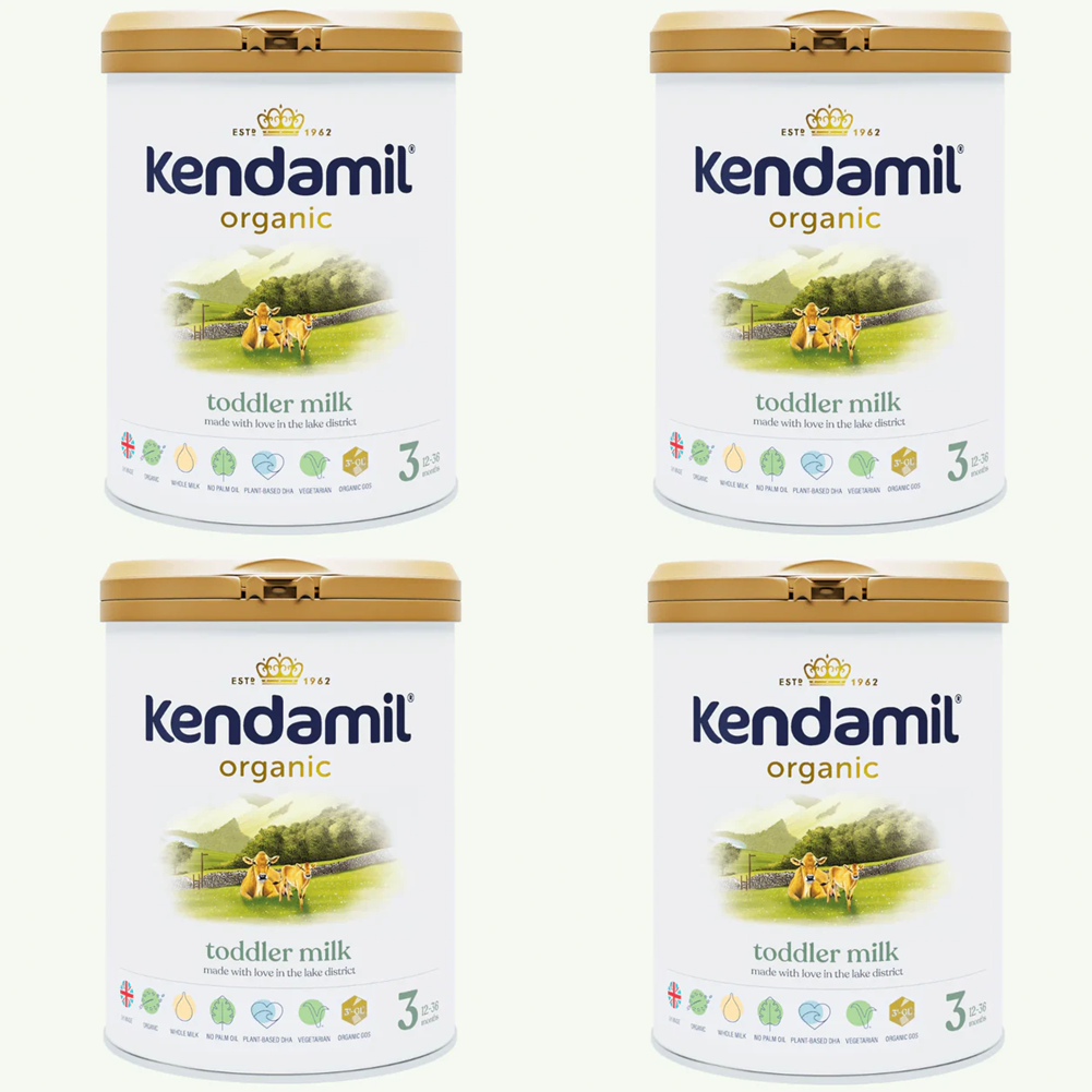 Four tins of Kendamil organic toddler milk on a white background