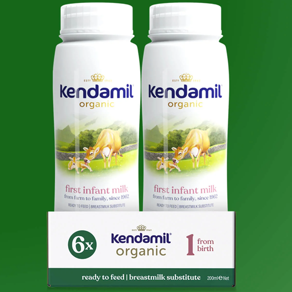 Two bottles of Kendamil organic first infant milk on a green background