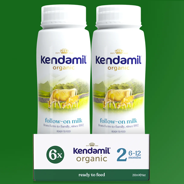 Two bottles of Kendamil organic follow-on milk with a box on a green background