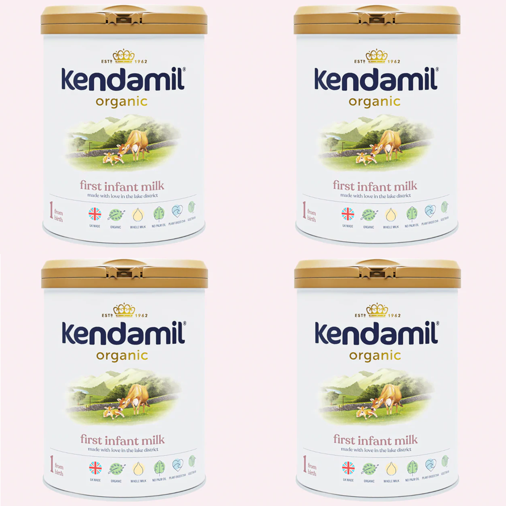 Four tins of Kendamil organic first infant milk on a white background